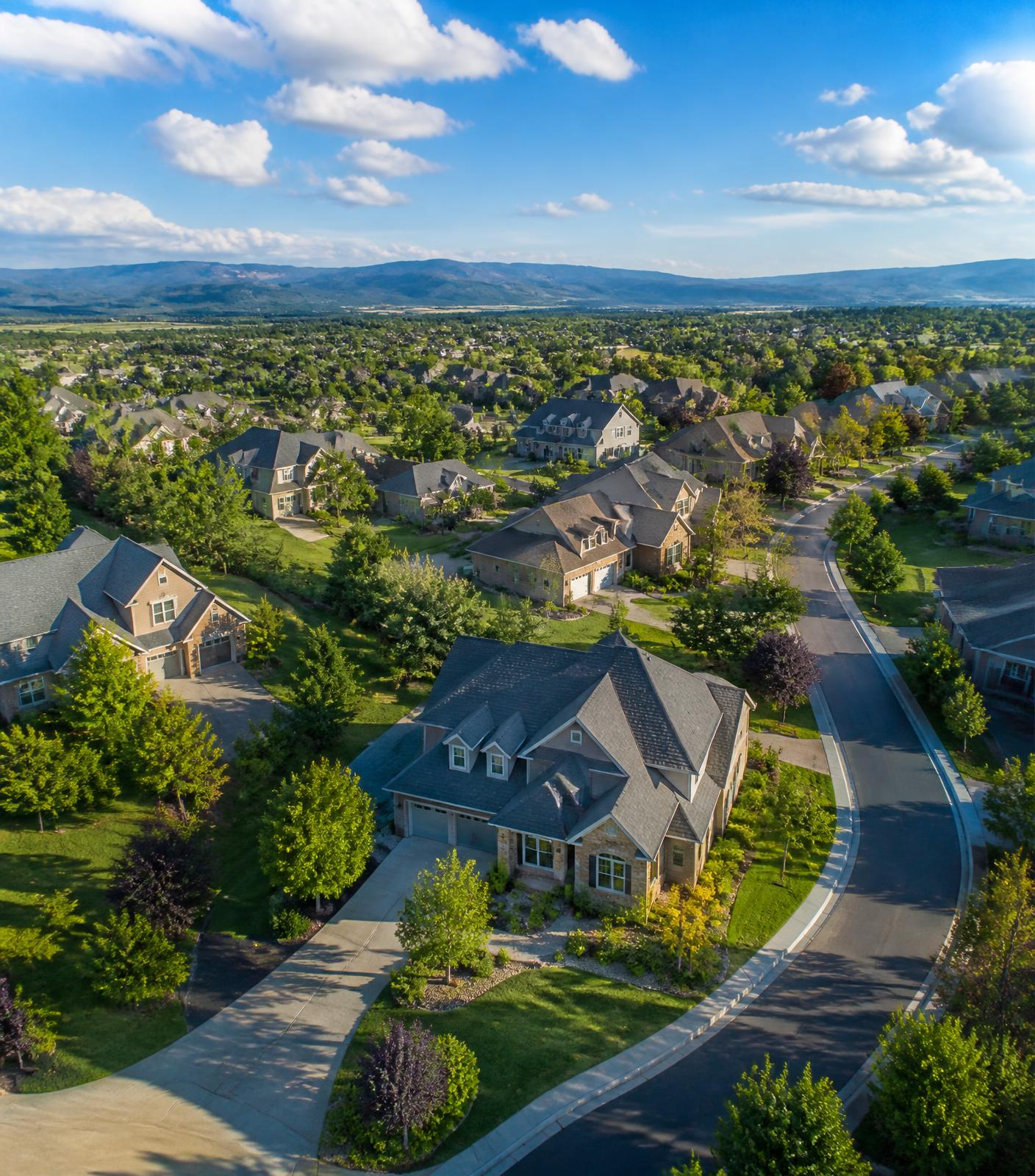 Bright daytime view of a modern residential neighborhood with green lawns and clear blue sky